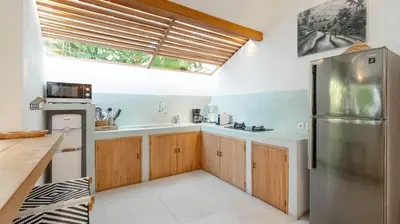a kitchen with a stainless steel refrigerator and a window at Villa Umara by Villa Finder in Seminyak