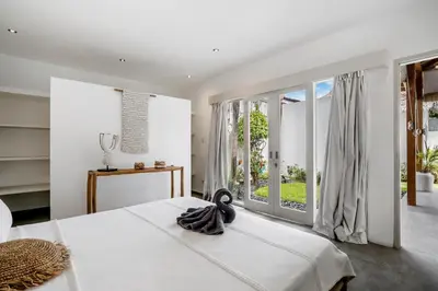 a bedroom with a bed and a large window at Villa Nakal by Alfred in Bali in Seminyak
