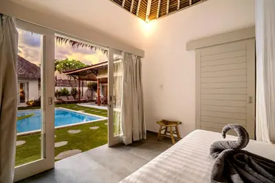 a bedroom with a bed and a view of a pool at Villa Nakal by Alfred in Bali in Seminyak