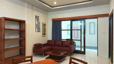 a living room with a leather couch and a table at The New Moon Seminyak in Seminyak