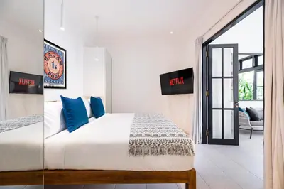a bedroom with a large bed with blue pillows at Villa Opihr in Seminyak