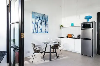 a kitchen with a table and chairs and a refrigerator at Villa Opihr in Seminyak