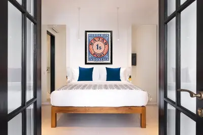 a bedroom with a king sized bed with blue pillows at Villa Opihr in Seminyak