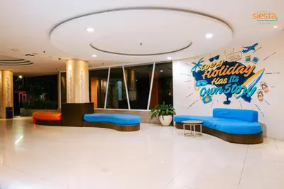 a lobby of a hotel with blue couches and a sign at Siesta Legian in Legian