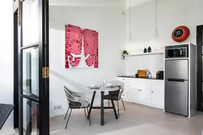 a kitchen with a table and chairs and a refrigerator at Villa Saffron in Seminyak