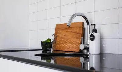 a kitchen sink with a cutting board and a faucet at Villa Saffron in Seminyak