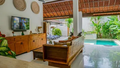 a living room with a swimming pool and a villa at Ahimsa Moon Villa Seminyak in Seminyak