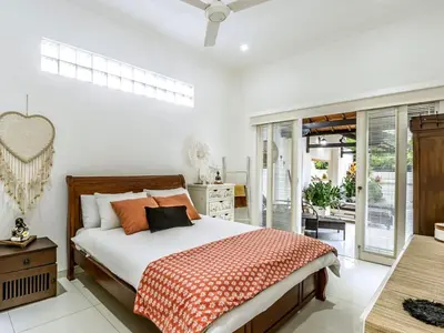 a bedroom with a large bed and a balcony at Ahimsa Moon Villa Seminyak in Seminyak