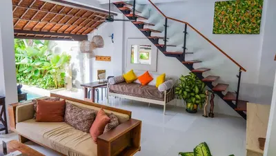 a living room with a couch and a staircase at Ahimsa Moon Villa Seminyak in Seminyak
