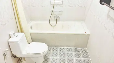 a bathroom with a toilet and a tub and a sink at Masainn Hotel Kuta in Kuta