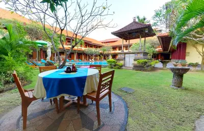 a table and chairs in the yard of a house at Masainn Hotel Kuta in Kuta