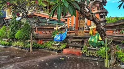 a building with two statues in front of it at Masainn Hotel Kuta in Kuta