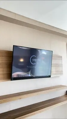 a flat screen tv sitting on top of a shelf at The Capital Hotel and Resort Seminyak in Seminyak