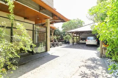 a building with a car parked next to a street at The Legian Mas Beach Inn in Kuta