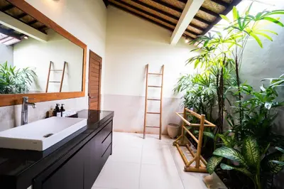 a bathroom with a sink and some plants at Villa Agni - BEST location! 3BR villa at the heart of Seminyak in Seminyak