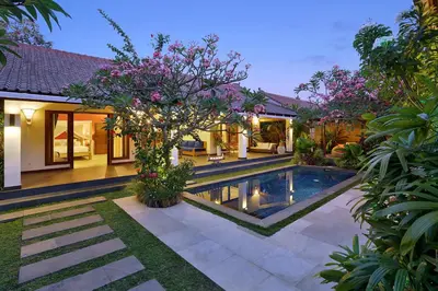 a villa with a swimming pool in a garden at Villa Agni - BEST location! 3BR villa at the heart of Seminyak in Seminyak