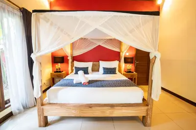 a bedroom with a large bed with a canopy at Villa Agni - BEST location! 3BR villa at the heart of Seminyak in Seminyak