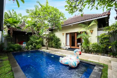 a pool in front of a house with a rubber duck in the yard at Villa Agni - BEST location! 3BR villa at the heart of Seminyak in Seminyak