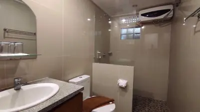 a bathroom with a sink and a toilet and a mirror at Manu Guest House 2 in Canggu