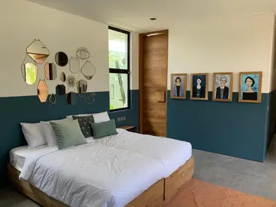 a bedroom with a large bed with pictures on the wall at Villa MOSAIC - Stunning Designed Spacious Villa - Center Canggu in Canggu