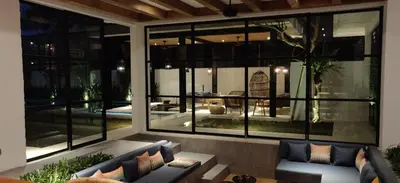 a living room with large glass windows and a couch at Villa MOSAIC - Stunning Designed Spacious Villa - Center Canggu in Canggu