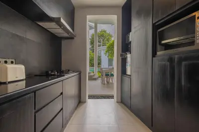 a kitchen with dark wood cabinets and a hallway at Taman Mesari Luxury Villas-Seminyak in Seminyak