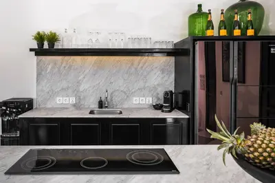 a kitchen with a sink and a refrigerator at Villa Nago Walk to Seminyak Best Spots in Seminyak