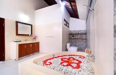 a bathroom with a bath tub with a flower rug at Sudha Villa Bali B in Seminyak