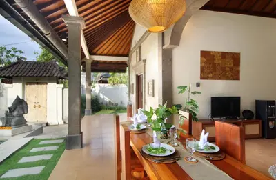 a dining room with a wooden table with chairs at Sudha Villa Bali B in Seminyak