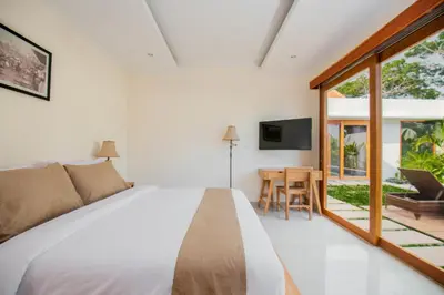 a bedroom with a bed and a sliding glass door at Taman Sari Pengubengan Villa in Kerobokan