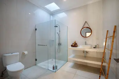 a bathroom with a shower and a toilet and a sink at Villa Maleena in Seminyak