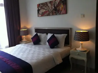 a bedroom with a bed with two lamps on tables at Villa Celavi 77 in Jimbaran