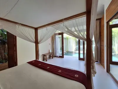 a bedroom with a bed with a canopy at Villa Beji in Seminyak