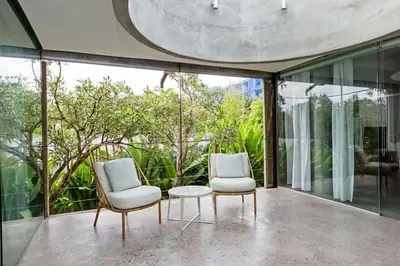 two chairs and a table in a room with windows at Villa C99 Seminyak in Kerobokan