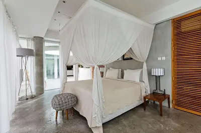 a bedroom with a white bed with a canopy at Villa C99 Seminyak in Kerobokan