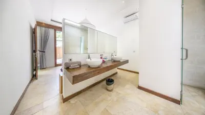 a bathroom with two sinks and a large mirror at Anema Villa Seminyak in Legian