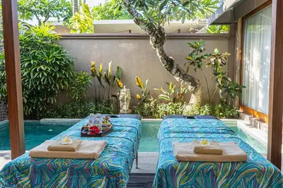 two beds sitting next to a pool in a backyard at Asa Bali Luxury Villas & Spa in Seminyak