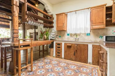 a kitchen with wooden cabinets and a counter top at Casa Jimbaran Villa in Jimbaran