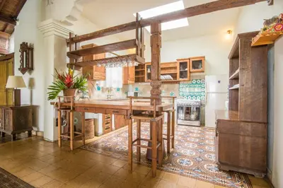 a kitchen with a wooden table and a refrigerator at Casa Jimbaran Villa in Jimbaran
