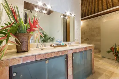 a bathroom with a sink and a large mirror at Casa Jimbaran Villa in Jimbaran