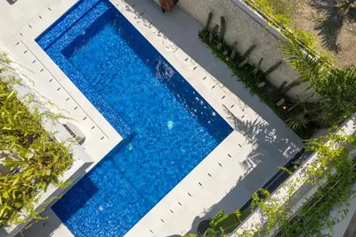 an overhead view of a swimming pool with blue water at Summer House Villa in Canggu