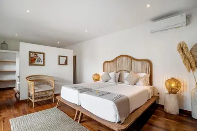 a bedroom with a large white bed and a chair at Villa Loma by Alfred in Bali in Seminyak