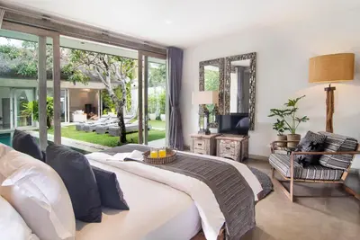 a bedroom with a bed and a large window at Villa Mia by Villa Finder in Canggu