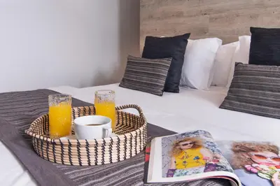 a bed with a tray of orange juice and a magazine at Villa Mia by Villa Finder in Canggu