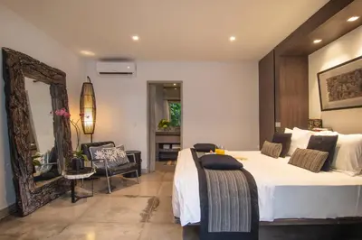 a bedroom with a large bed and a mirror at Villa Mia by Villa Finder in Canggu