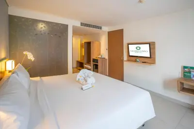 a teddy bear sitting on a bed in a hotel room at Grand Livio Kuta Hotel in Legian
