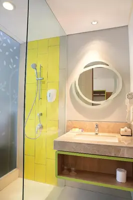 a bathroom with a sink and a mirror at Grand Livio Kuta Hotel in Legian