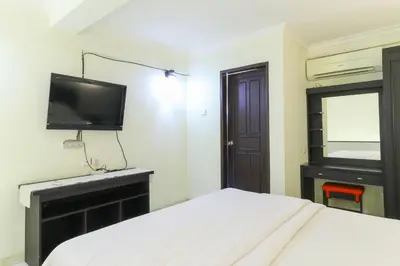 a bedroom with a bed and a tv on the wall at Permisol Homestay 88 in Denpasar