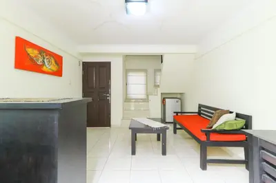 a living room with a red bench and a table at Permisol Homestay 88 in Denpasar