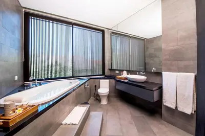 a bathroom with a tub and a toilet and a sink at Villa DeDayuh Seminyak in Seminyak